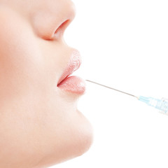 A young woman getting a botox injection into her lips
