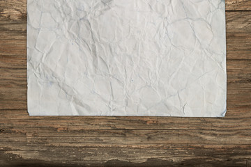 Empty crumpled paper on wood