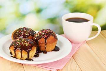 Appetizing cupcakes with chocolate on nature background