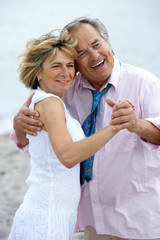 Älteres Paar tanzt am Strand