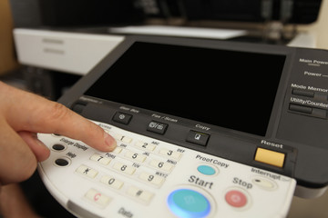 Finger pressing of keyboard buttons of the laser copier