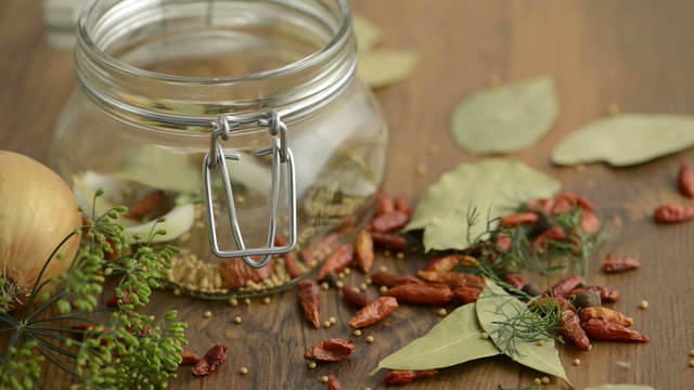 Gew&uuml;rze und Gurken fallen in Einweckglas
