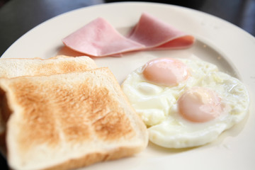 Breakfast with ham , fried egg and bread