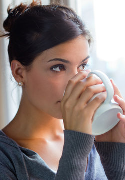 beautiful young woman having coffee  at home
