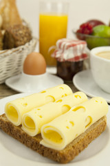 Frühstück mit toast, käse, ei und früchten auf einem Tisch