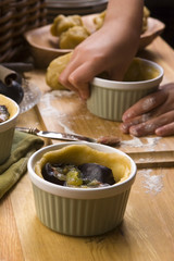 Detail of child hands making plum tart