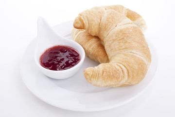 frisches croissant mit erdbeer marmelade isoliert auf weiß