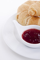 frisches croissant mit erdbeer marmelade isoliert auf weiß