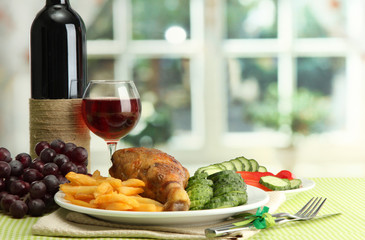 Roast chicken with french fries and cucumbers, glass of wine