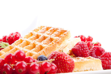 Frische süße Waffeln mit Puderzucker und beeren auf einem Tell