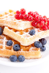 Frische süße Waffeln mit Puderzucker und beeren auf einem Tell