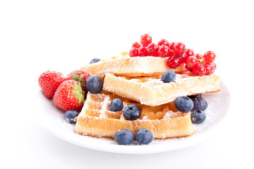 Frische süße Waffeln mit Puderzucker und beeren auf einem Tell