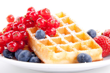 Frische süße Waffeln mit Puderzucker und beeren auf einem Tell