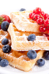 Frische süße Waffeln mit Puderzucker und beeren auf einem Tell