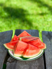 cut water melon on wooden table in the garden