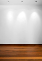 Naklejka premium Empty white wall with 3 spot lights and wooden floor