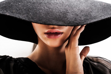 girl in black hat touching face and lips - 44400898