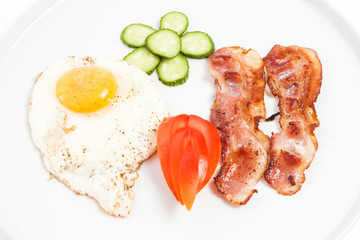 fried eggs, bacon and vegetables on white background