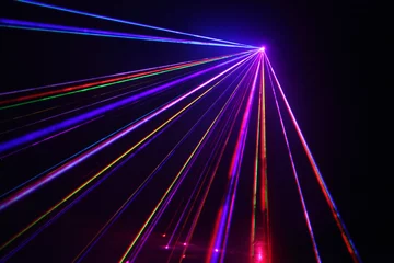 Crédence de cuisine en verre imprimé Lumière et ombre Beaucoup de beaux faisceaux laser multicolores dans le noir à la discothèque.