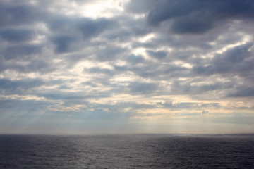 gray clouds over dark and cold sea;