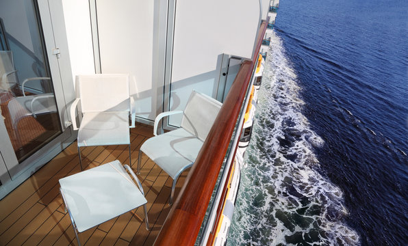 balcony with white chairs and table on ship with view on ship