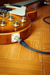 electric guitar on floor with cable