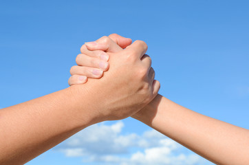 Partner hand between a man and woman on sky background, Teamwork