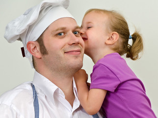 Little girl and her father having fun in the kitchen