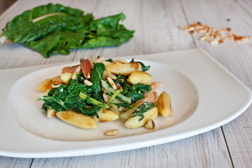 fresh salad with chard noodles and pine nuts on wooden table