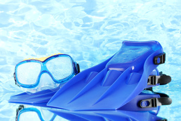 blue flippers and mask on blue sea background © Africa Studio