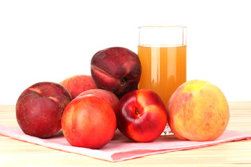 Ripe peaches and juice on wooden table on white background