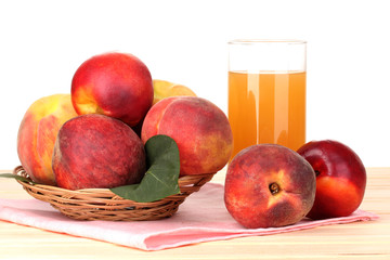 Ripe peaches and juice on wooden table on white background