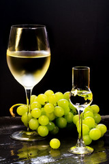 wine and grappa glass with grapes bunch