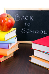 Back to school sign on a blackboard with books and apple