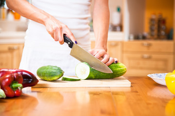 Human hands cutting vegetables for salad
