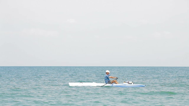 A man kayaking in the sea on a sunny day