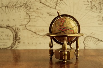 Globe  against map on a wall