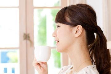 Beautiful young woman drinking coffee. Portrait of asian.