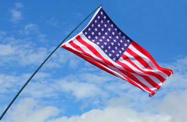 American flag waving against blue sky.