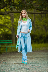 attractive young woman in jeans walking in the park