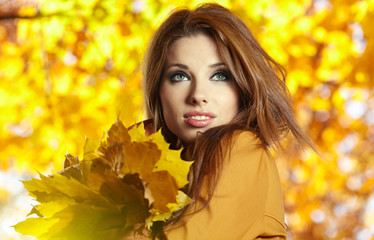 Naklejka na ściany i meble Młoda kobieta z jesieni pozostawia w ręku i spadnie żółty klonowy gar