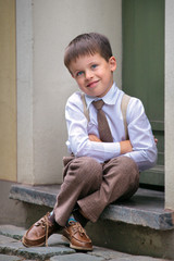 Portrait of a happy little boy outdoors in city