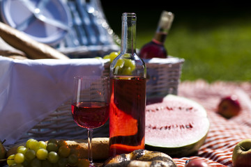 Wine and picnic basket on the grass 