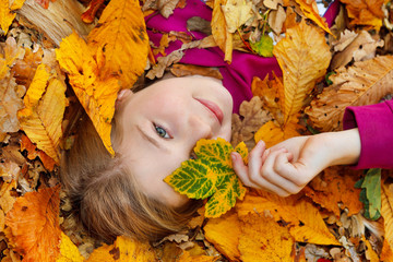 girl on autumn leaves smiling