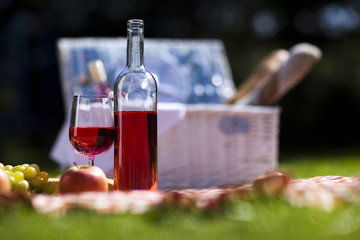 Wine and picnic basket on the grass 