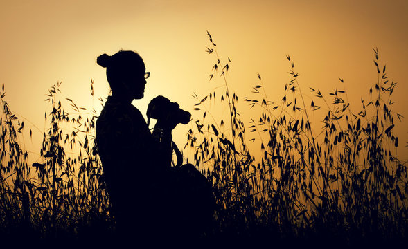 Silhouette of female photographer at sunrise