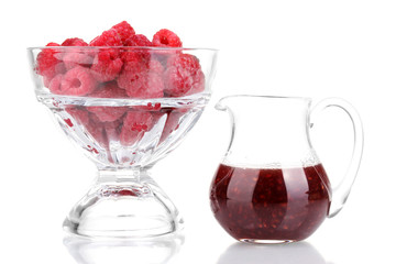 Raspberries in glass and jug with jam isolated on white