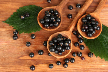 Fresh black in wooden spoons on wooden background close-up