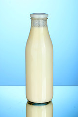 bottle of milk on blue background close-up