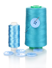 Blue bobbin with needle and buttons isolated on white